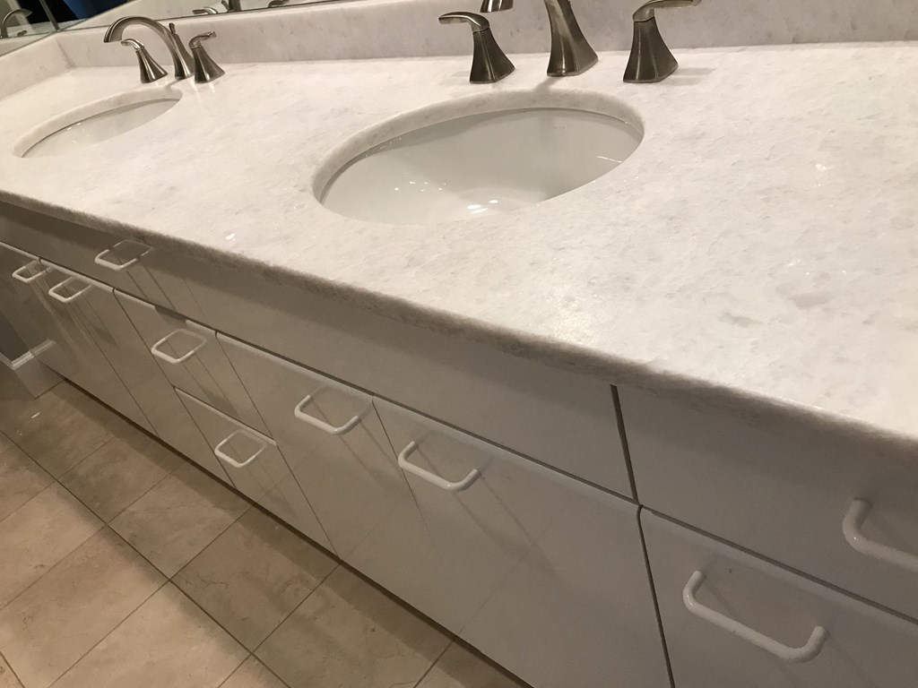a close up of a bathroom sink with a marble counter top