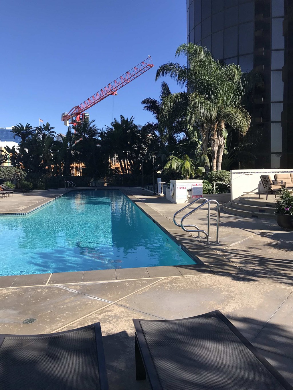 a swimming pool at a hotel with a crane in the background