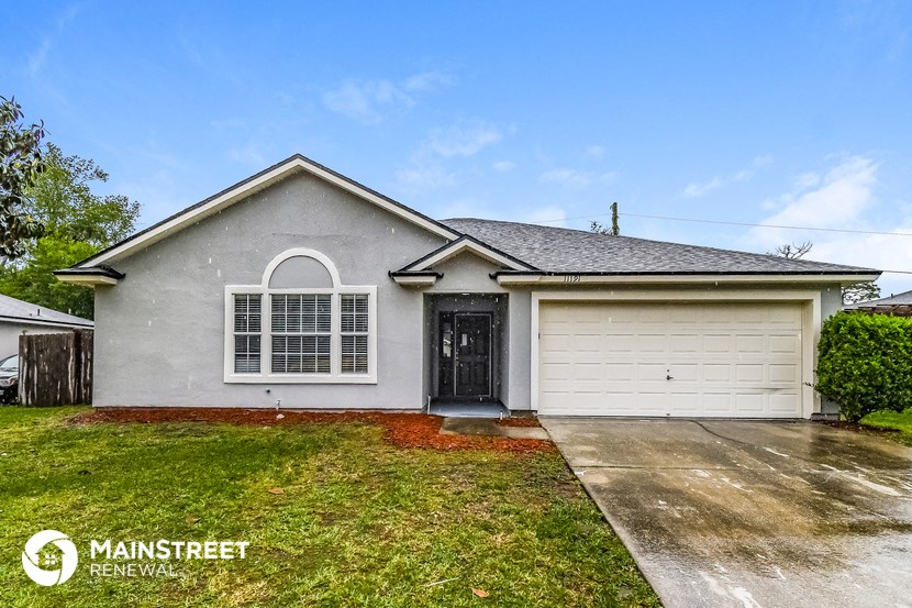 the front of a house with a driveway and a white garage door