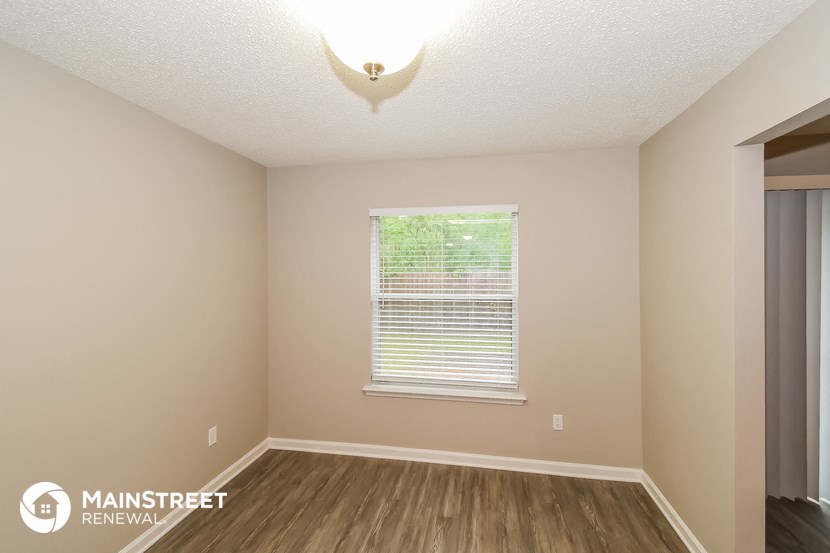 the interior of an empty room with wood floors and a window