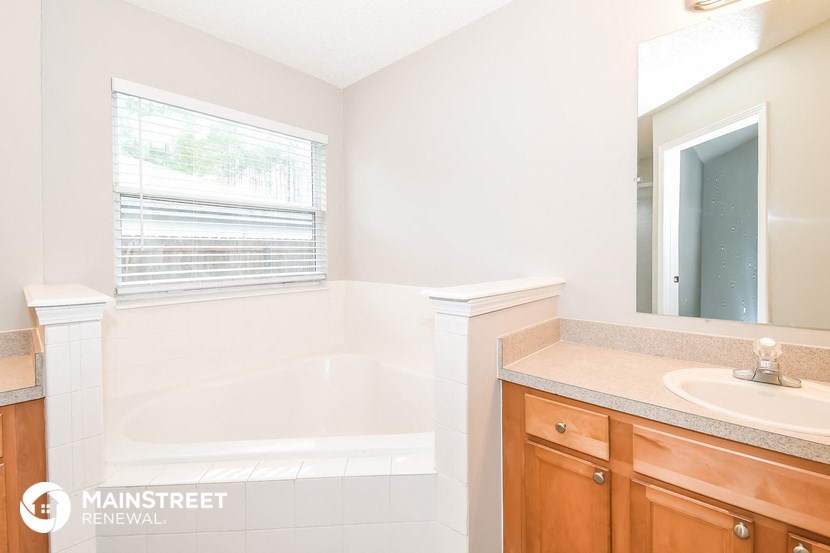 a bathroom with a tub and a sink and a mirror