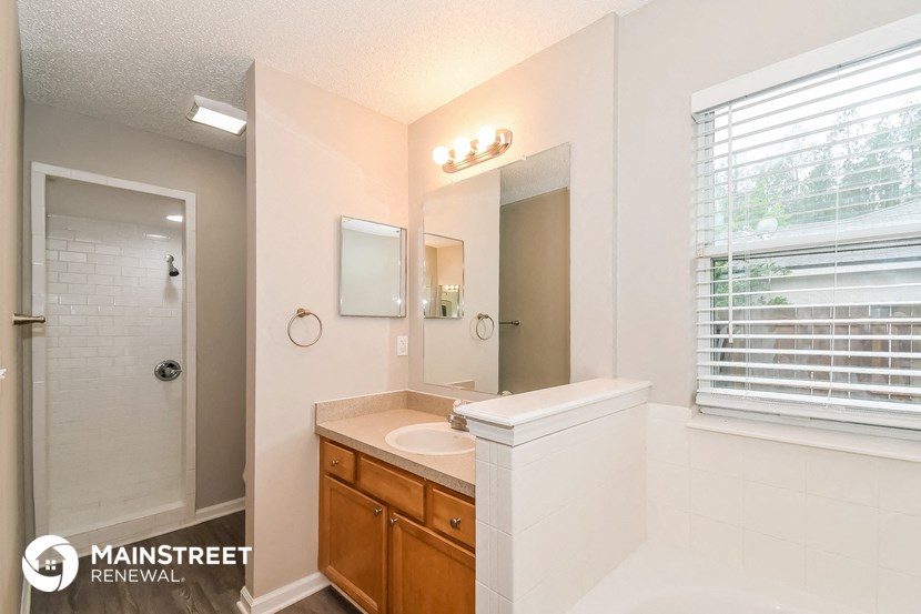 a bathroom with a sink and a shower and a mirror