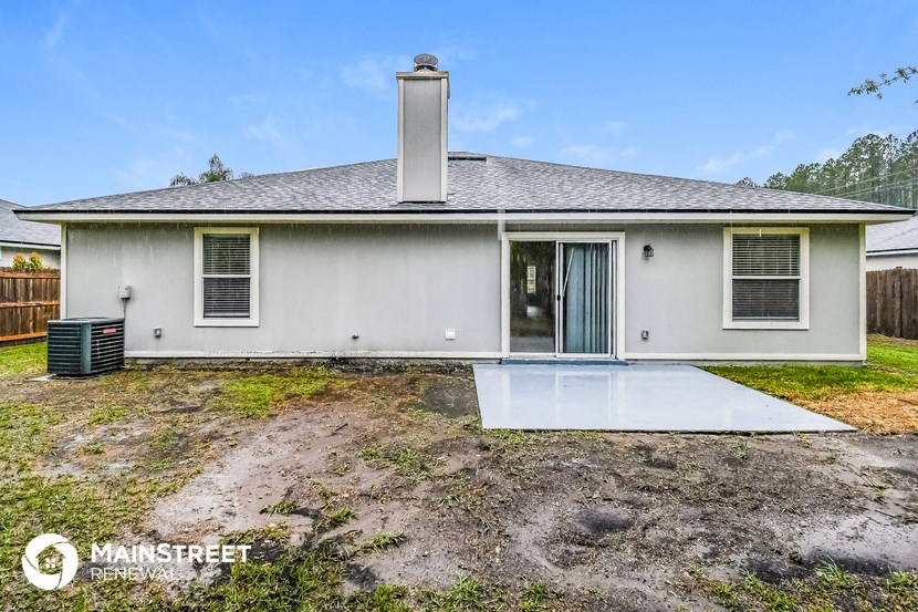 the front of a house with a patio and a yard