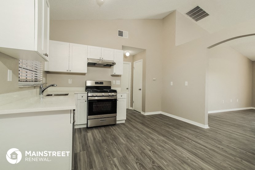 the kitchen of an apartment with white cabinets and stainless steel appliances