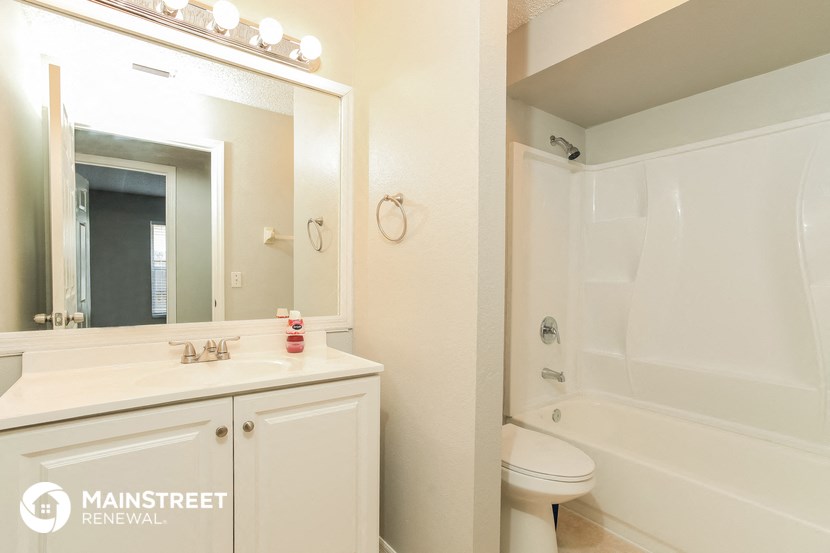 a bathroom with a sink toilet and shower and a mirror