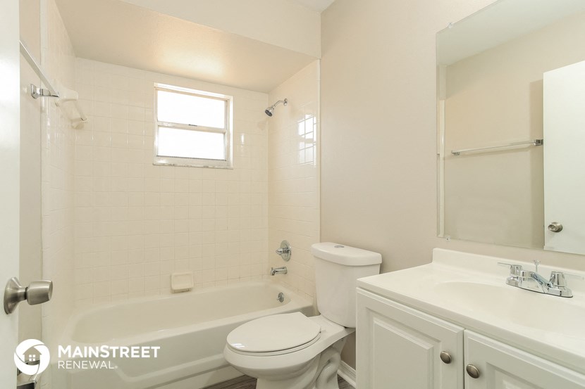 a white bathroom with a tub and a toilet and a sink