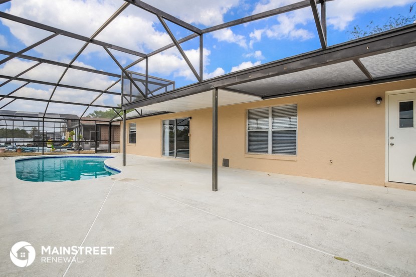 the pool is under a glass roof in the backyard of a house with a pool