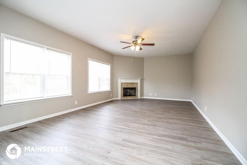 the living room with fireplace and ceiling fan