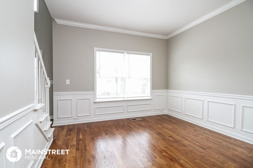 an empty room with wooden floors and a window