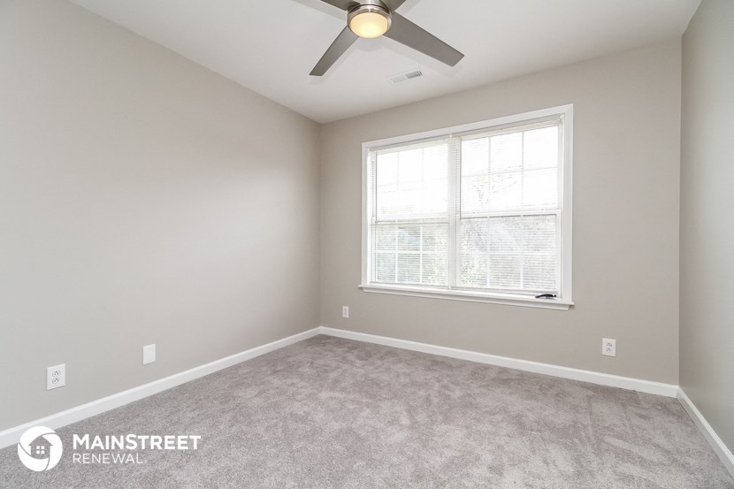 a bedroom with a ceiling fan and a window