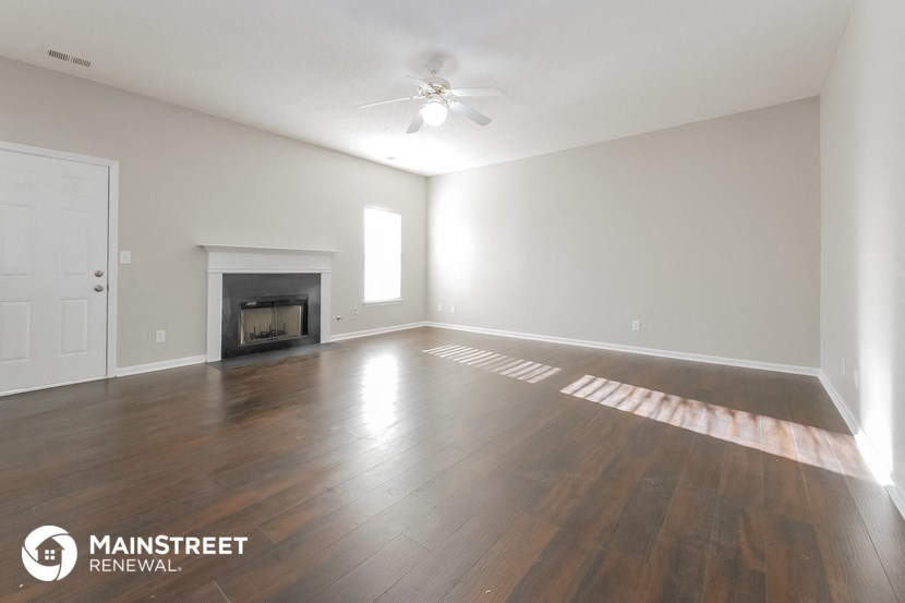 the spacious living room with wood flooring and a fireplace