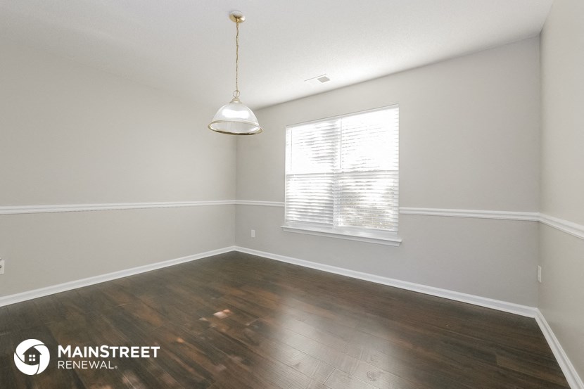 the interior of an empty room with wood flooring and a window
