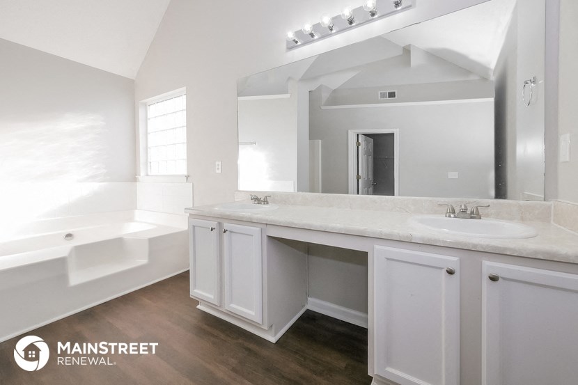 a white bathroom with a sink and a tub and a large mirror