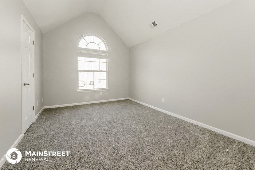 the master bedroom with carpeted flooring and a large window