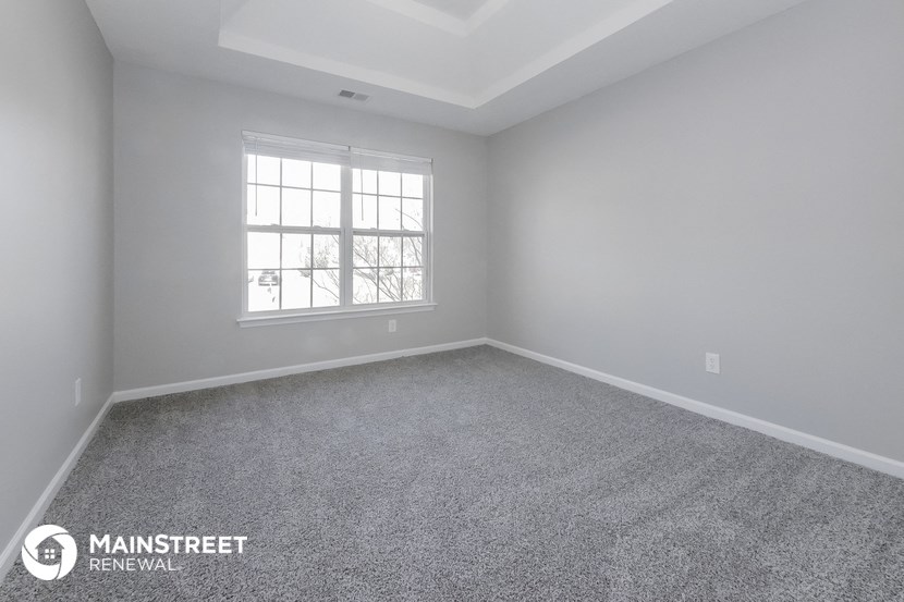the master bedroom of a new home with carpet and a window