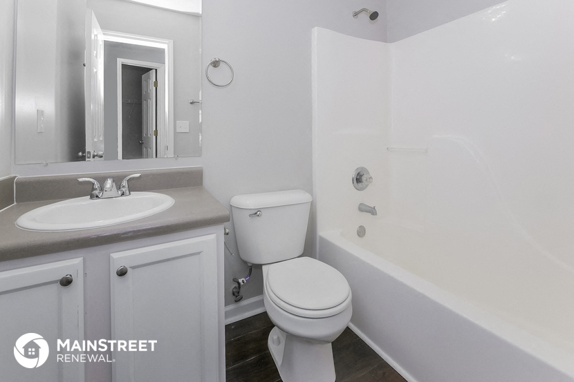 a bathroom with a toilet and a sink and a bath tub