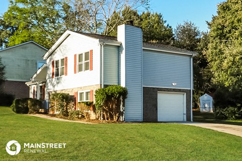 a blue and white house with a yard and a garage