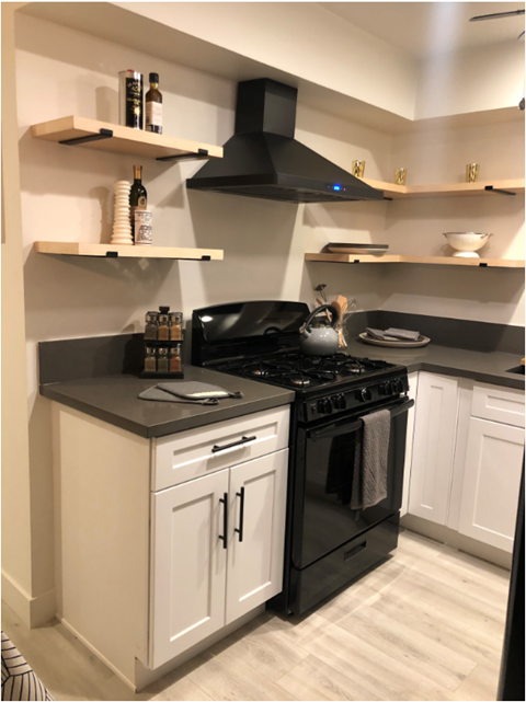 a small kitchen with a black stove and white cabinets