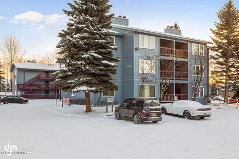 a car parked in the snow in front of a building