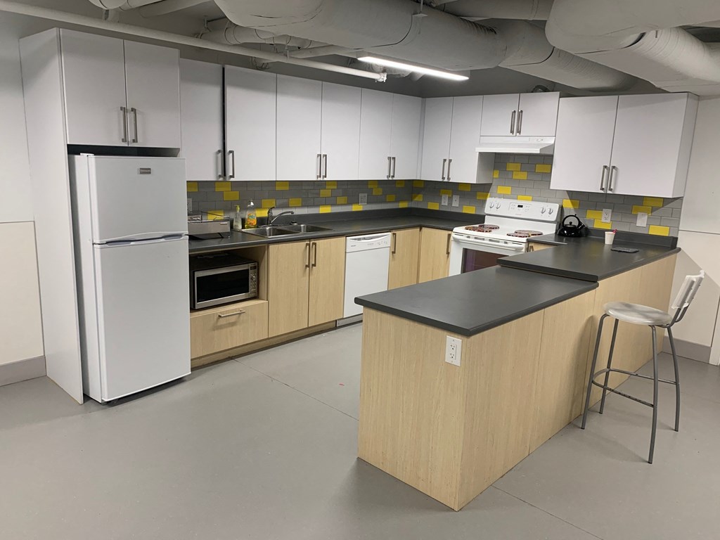 a kitchen with white cabinets and counters and a refrigerator
