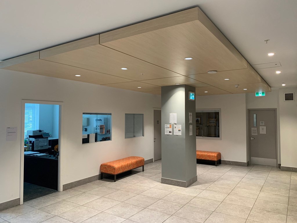 a large lobby with orange benches and a pillar