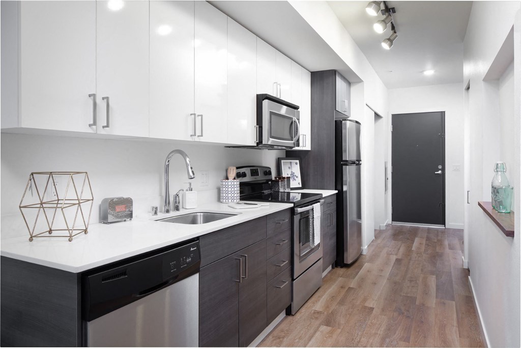 a kitchen with white cabinets and black appliances