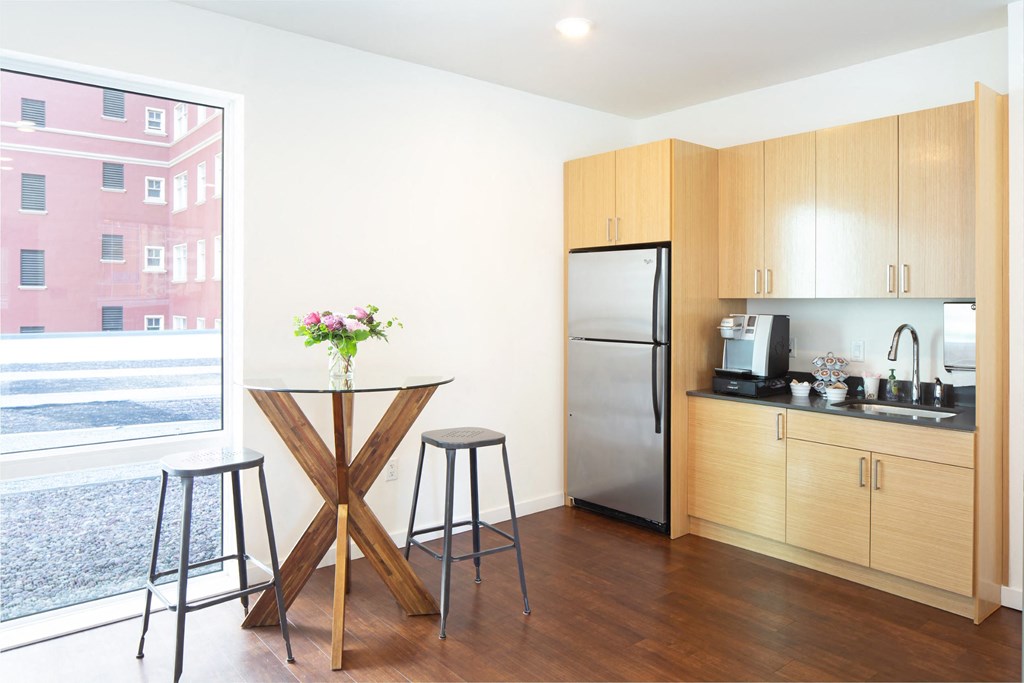 a kitchen with a small table and a refrigerator