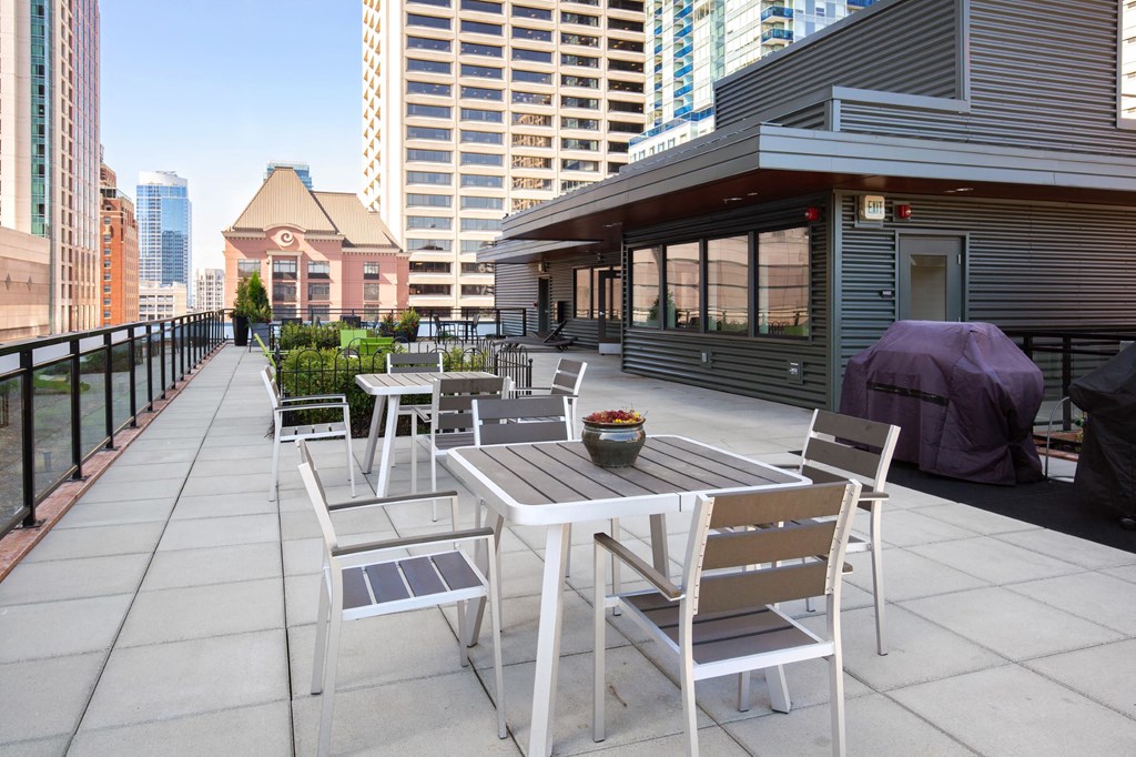 a patio with a table and chairs on a rooftop