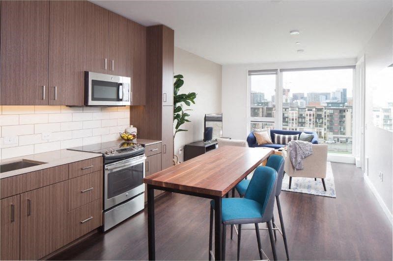a kitchen and living room with a wooden table