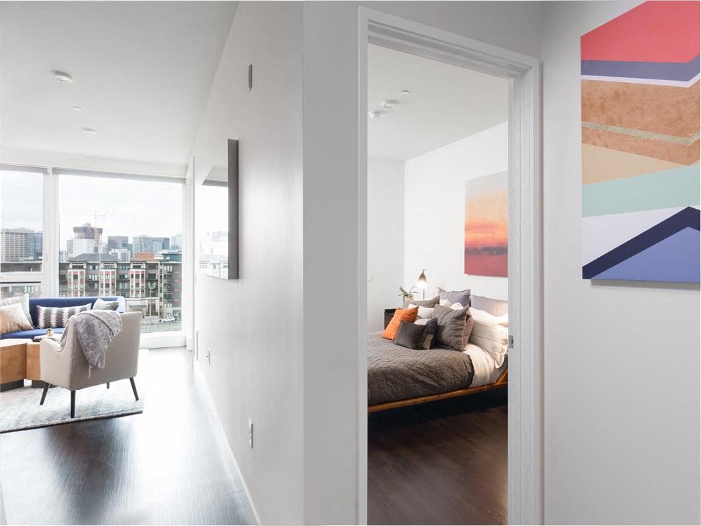 a bedroom with a bed and a living room with a window