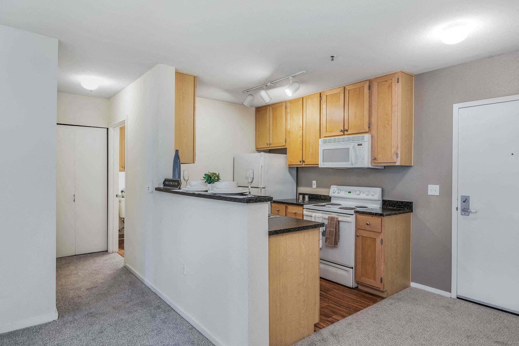 a kitchen with wood cabinets and white appliances and a counter top