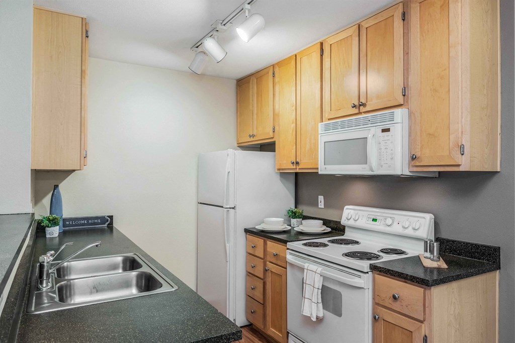 a kitchen with white appliances and wooden cabinets