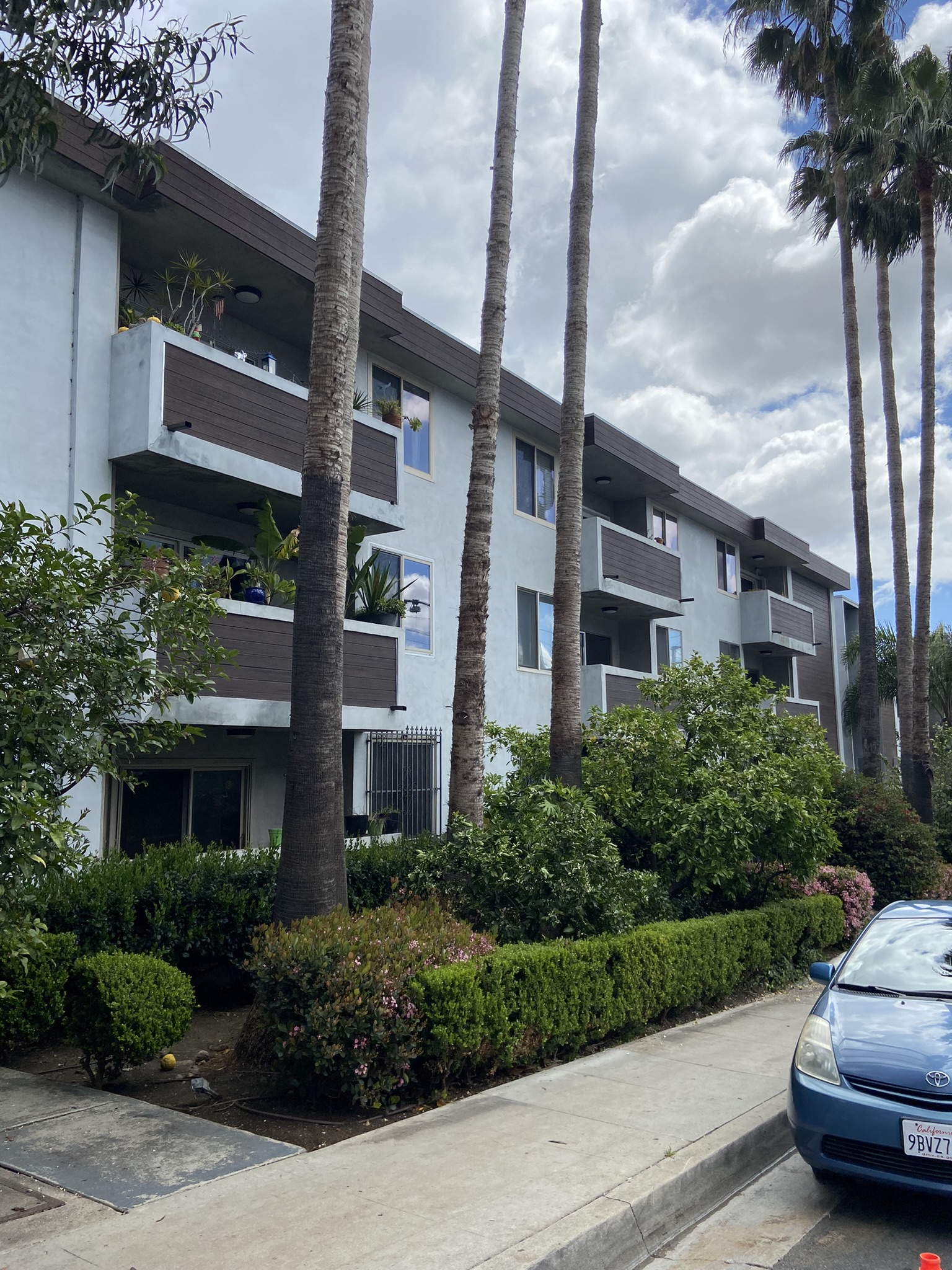an apartment building on a street with palm trees