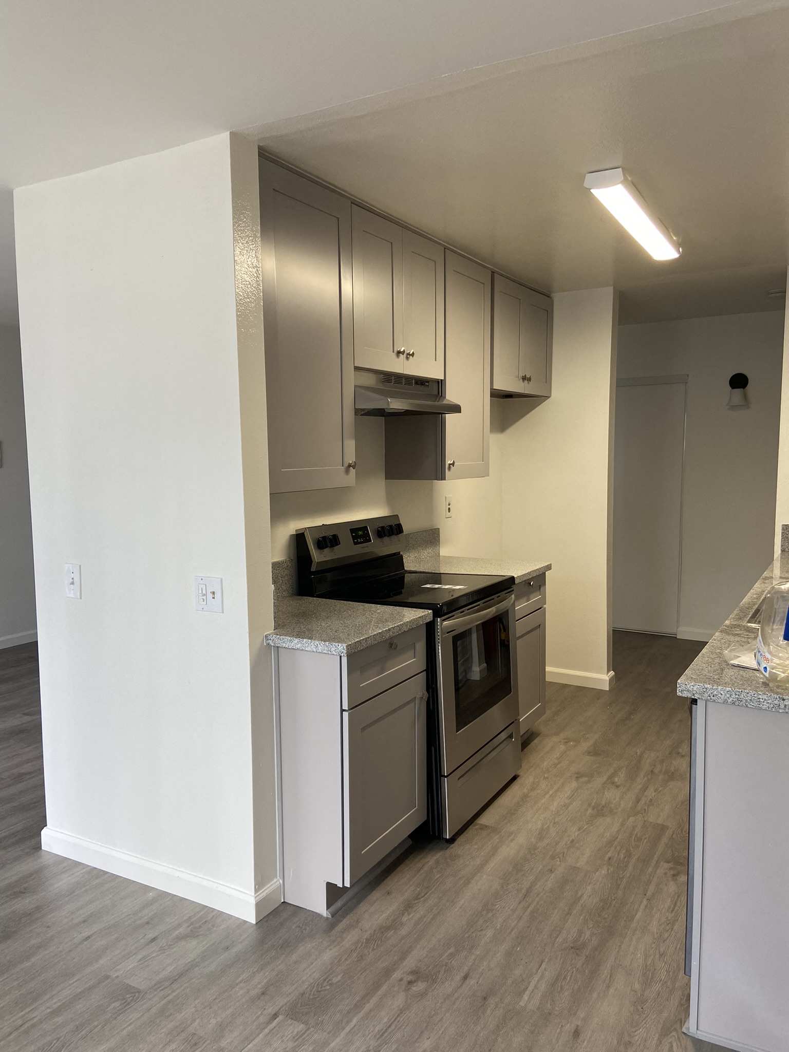 an empty kitchen with stainless steel appliances and white cabinets