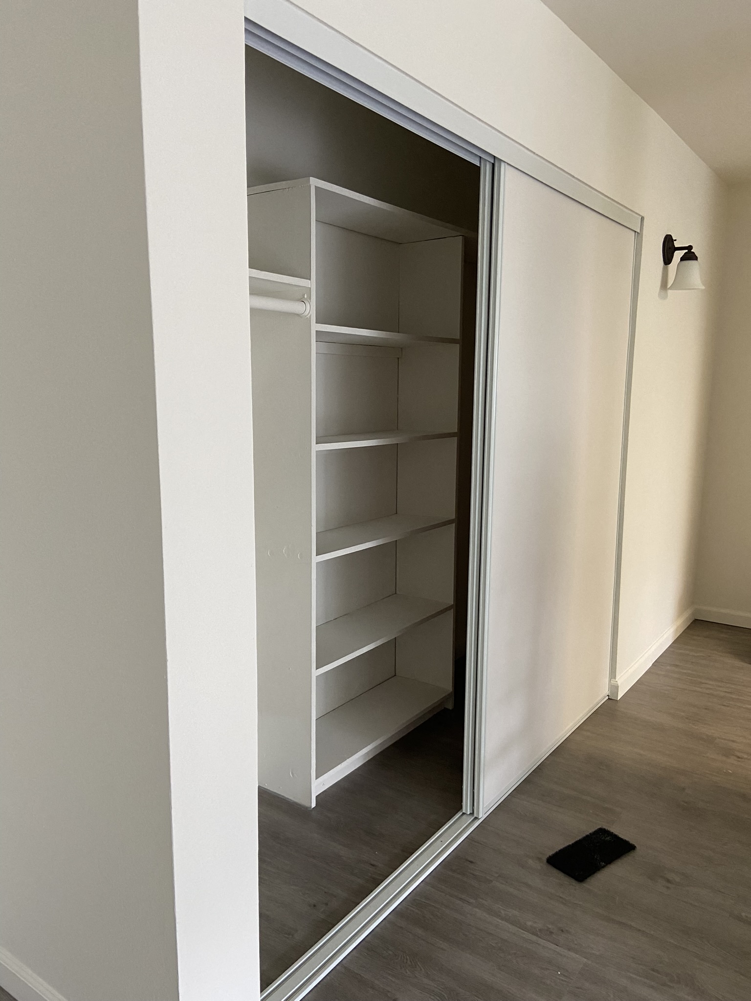 a closet with a mirrored door and shelves in it