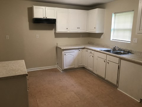 A kitchen with white cabinets and a countertop.