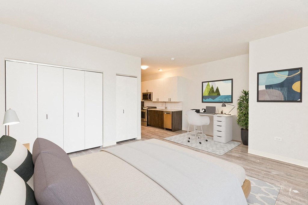 a bedroom with a bed and a desk and a living room