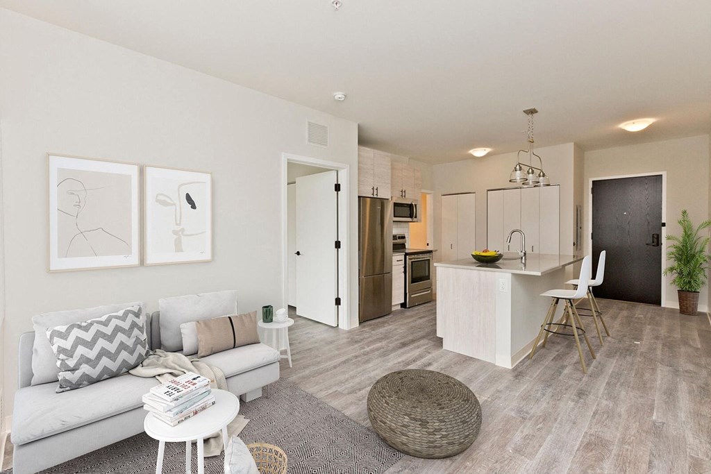 a living room and kitchen with a couch and a table