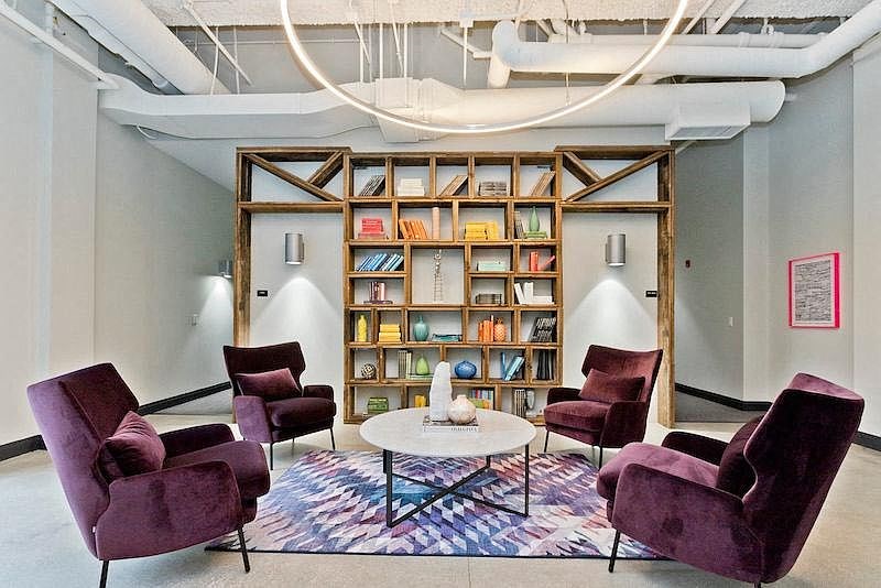 a living room with purple chairs and a table