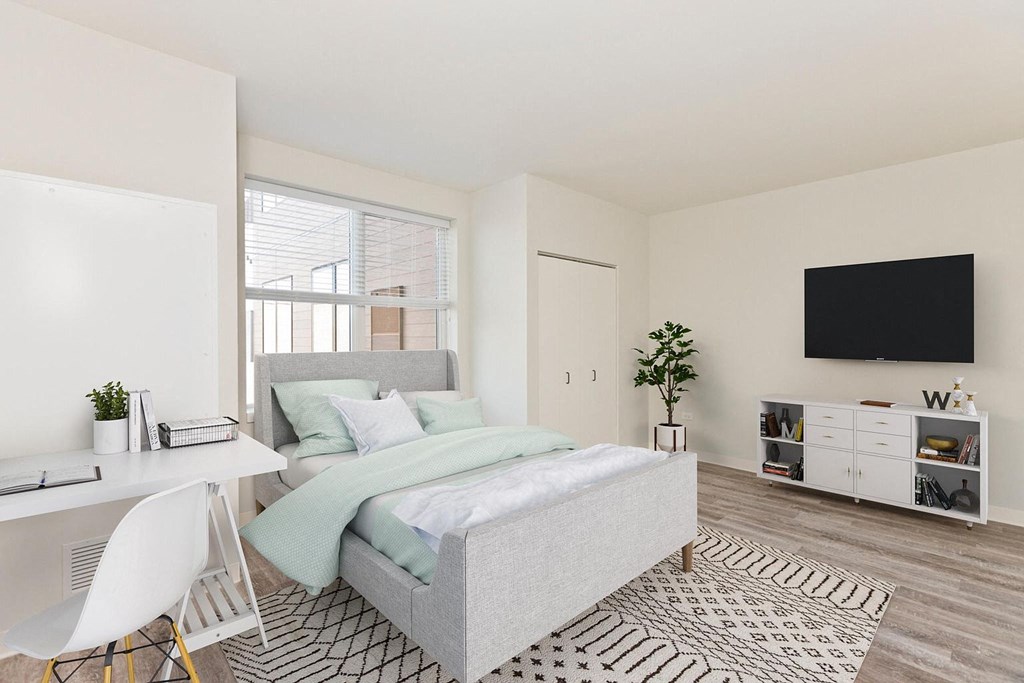 a bedroom with a bed and a desk and a tv