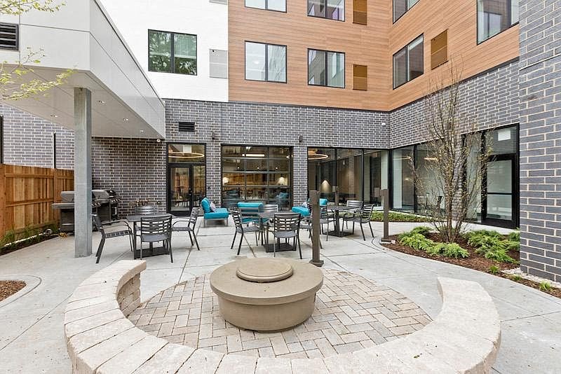 a courtyard with tables and chairs outside of a building