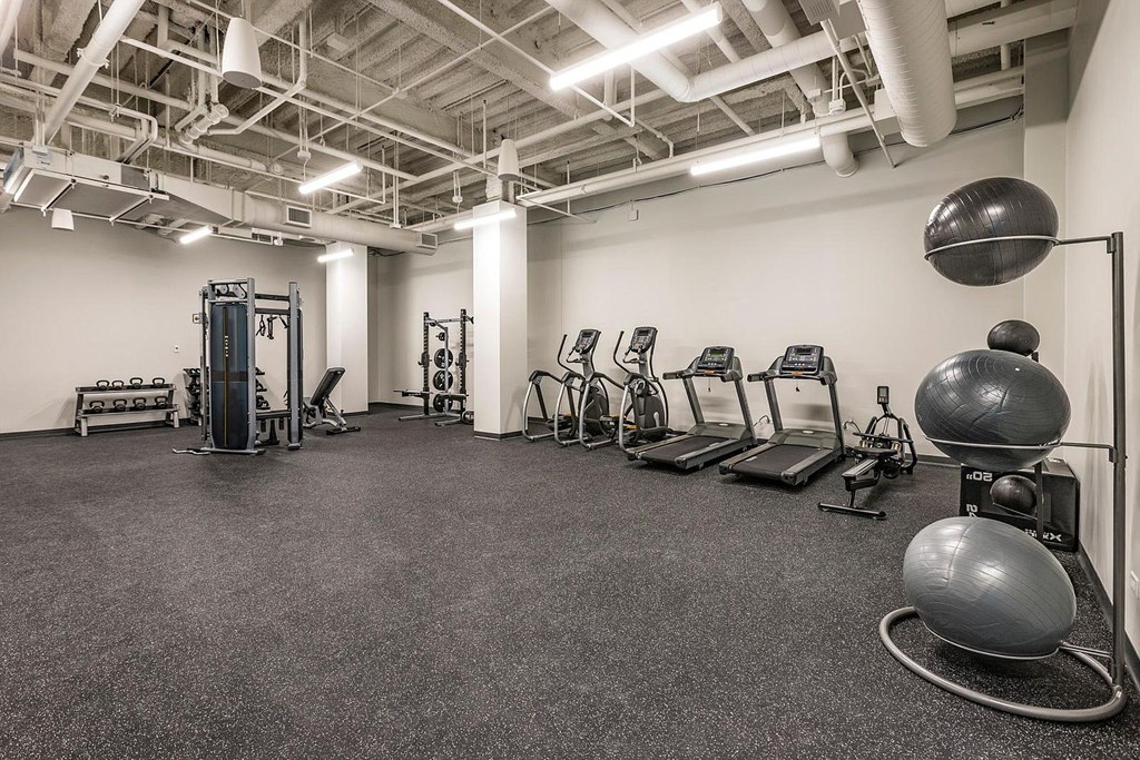 a gym with cardio equipment and weights in a building