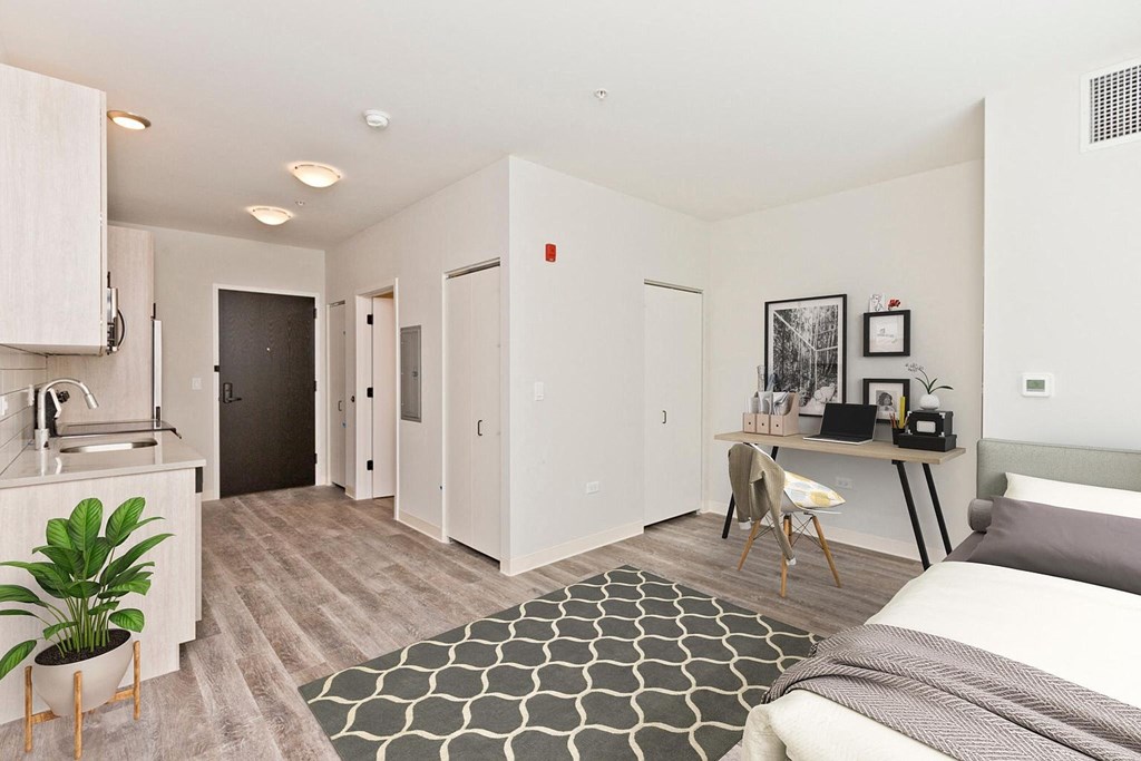 a bedroom with a bed and a desk in a room