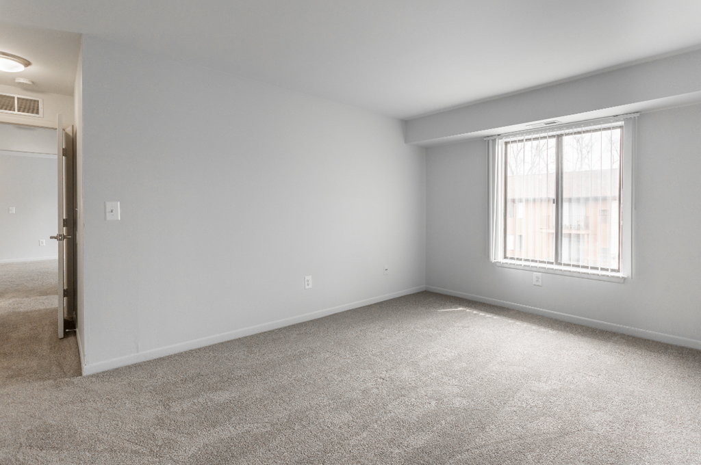 an empty room with carpet and a window