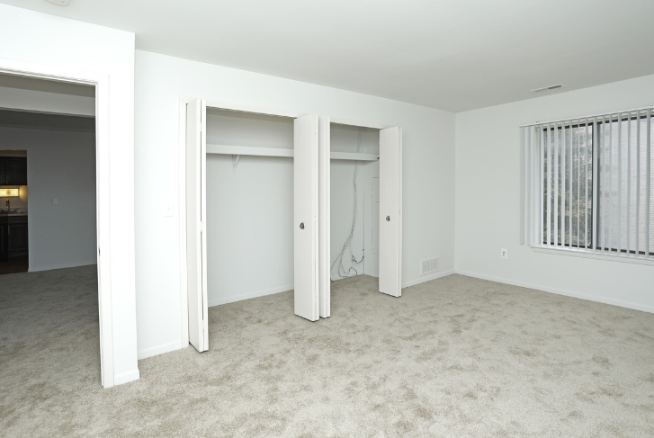 an empty living room with three closet doors in it