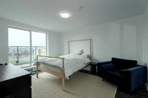 a bedroom with a bed and a black couch