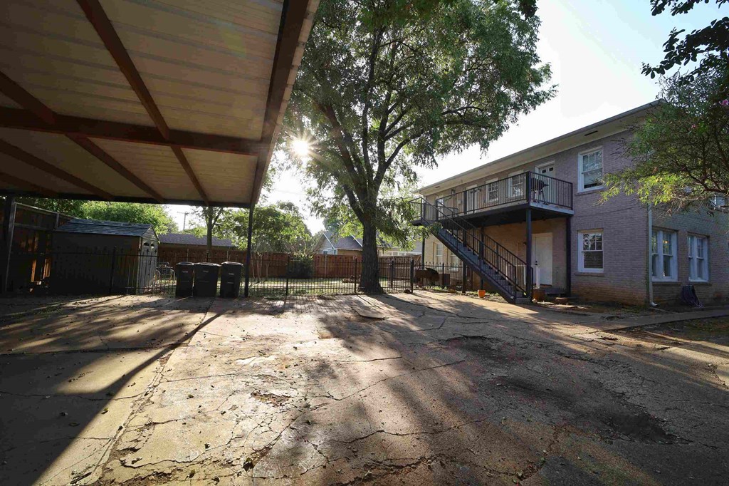 an empty lot with a house and a tree