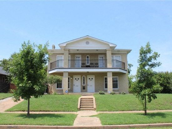 a large house with a porch and a lawn