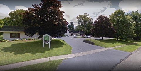 A street view with a green sign in the foreground.