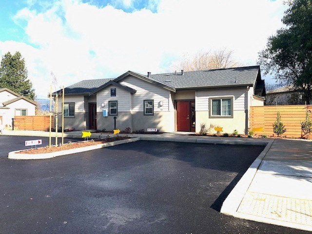 a white house with a driveway and a parking lot